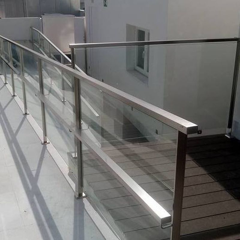 Barandillas de acero inoxidable y vidrio diseñada y montada en hotel para acceso a piscina.