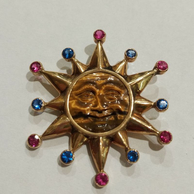 Colgante de sol en oro de 18k con ojo de tigre y vidrios. 1980.: Catálogo de Antigua Joyeros