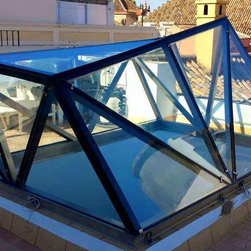 Montera de diseño de acero inoxidable y vidrio montada como punto de luz para patio interior.
