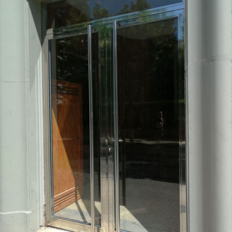 Puerta de acero inoxidable con vidrios de seguridad fabricada a medida.
