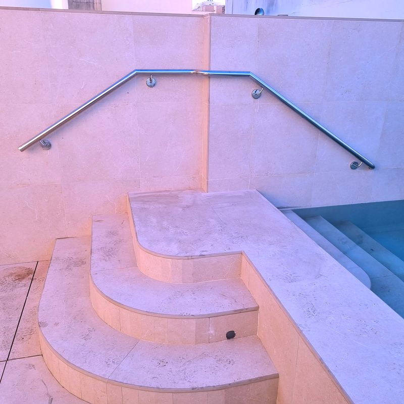 Pasamanos de acero inoxidable anclado a pared para acceso a piscina