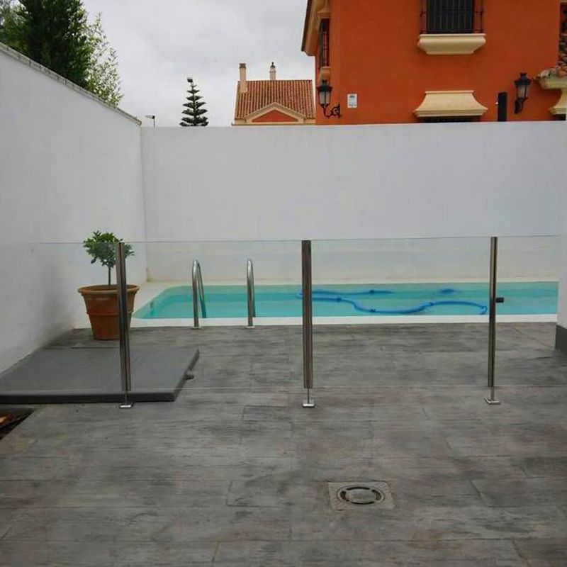 Barandilla de acero inoxidable y vidrio con puerta de acceso a piscina diseñada y fabricada a medida para vivienda particular