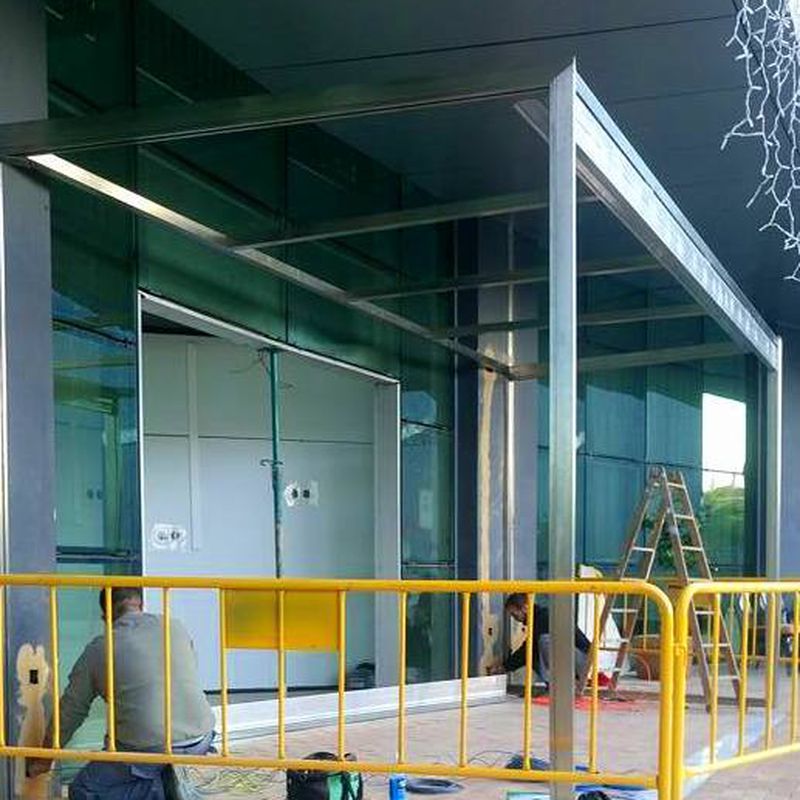 Cerramiento de puertas abatibles con fijos fabricada y montada en edificio de la junta de Andalucía