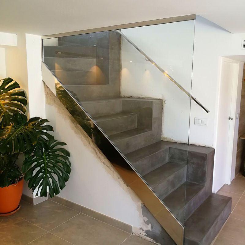 Barandilla de acero inoxidable y vidrio con pasamanos de acero inoxidable diseñada y fabricada a medida para vivienda particular.