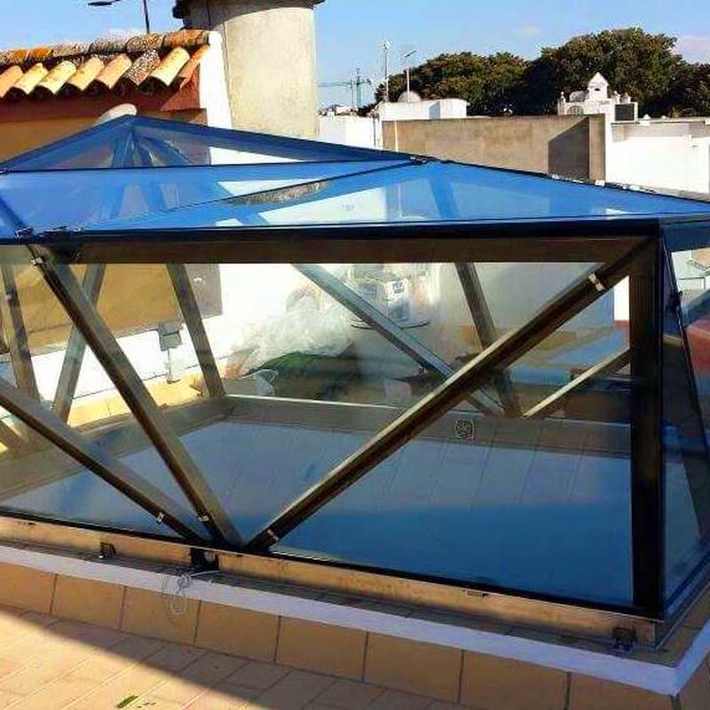 Montera de diseño de acero inoxidable y vidrio montada como punto de luz para patio interior.