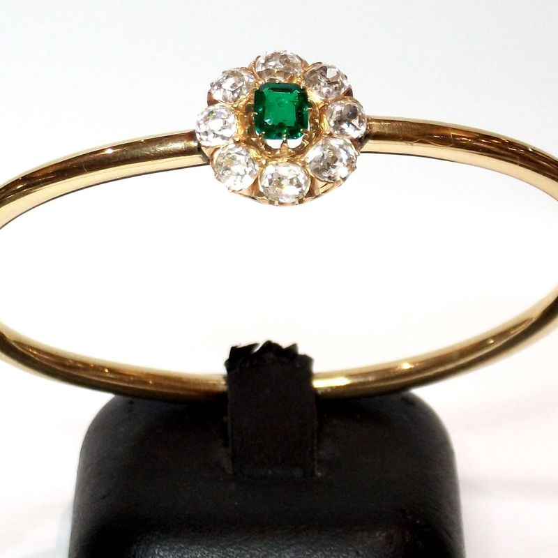 Pulsera rígida de oro de 18k con esmeralda y orla de diamantes.: Catálogo de Antigua Joyeros