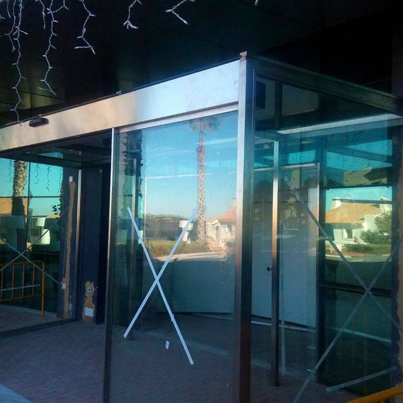 Cerramiento de puertas abatibles con fijos fabricada y montada en edificio de la junta de Andalucía