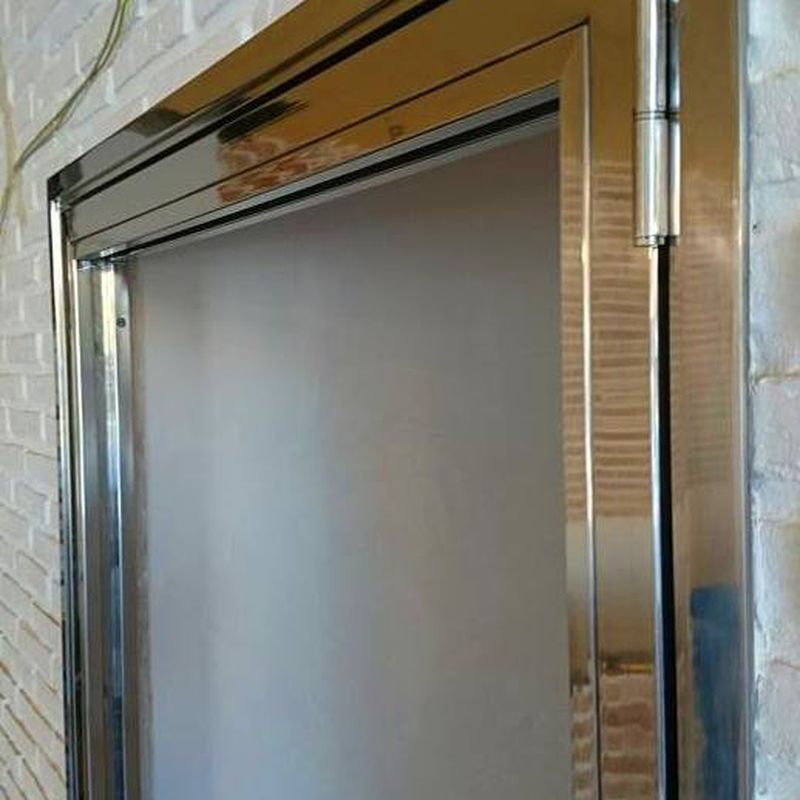 Puerta de acero inoxidable y vidrio fabricada a medida para entrada a bodega