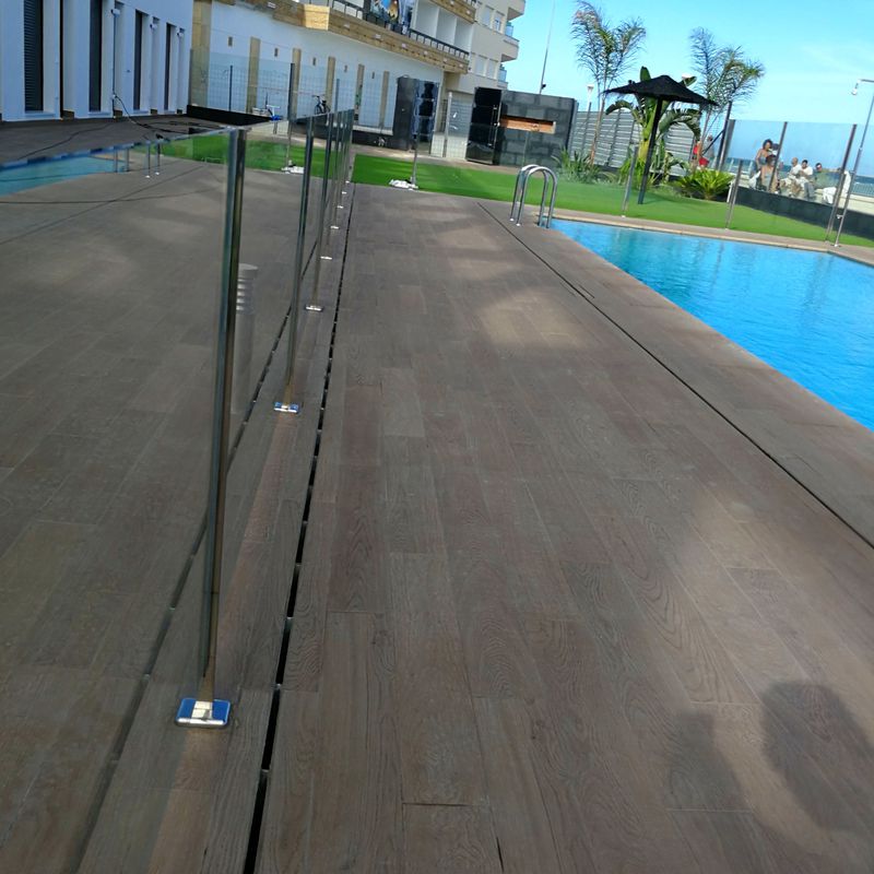 Barandilla de acero inoxidable y vidrio con puerta de acceso a piscina diseñada y fabricada a medida.