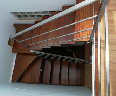 Barandilla de acero inoxidable montada en escalera de diseño de vivienda particular.