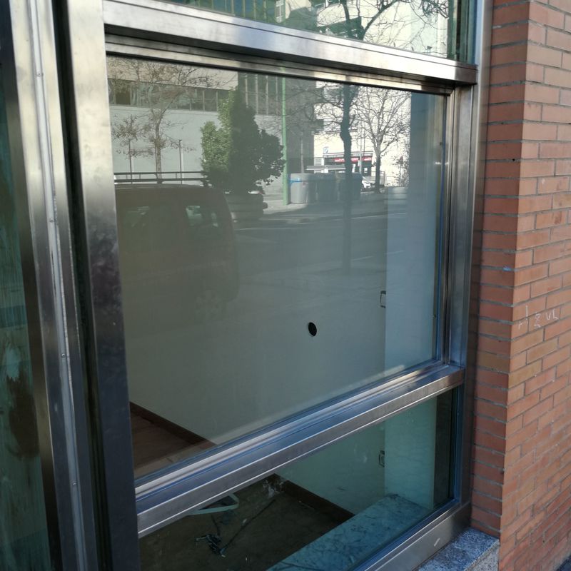Ventana guillotina de acero inoxidable y vidrio montada en escaparate comercial