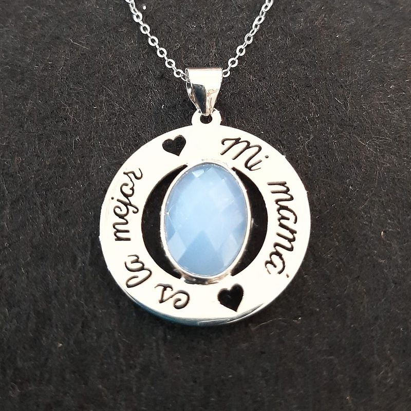 Colgante en plata de ley con frase calada y piedra azul central: Catálogo de Joyería Izquierdo