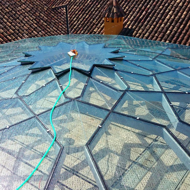 Estructura de acero negro y vidrio en forma de estrella para techo de patio andaluz de palacete