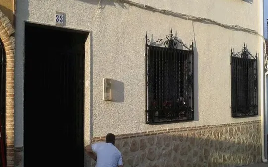 Fachada con zocalo imitación piedra y ladrillo.