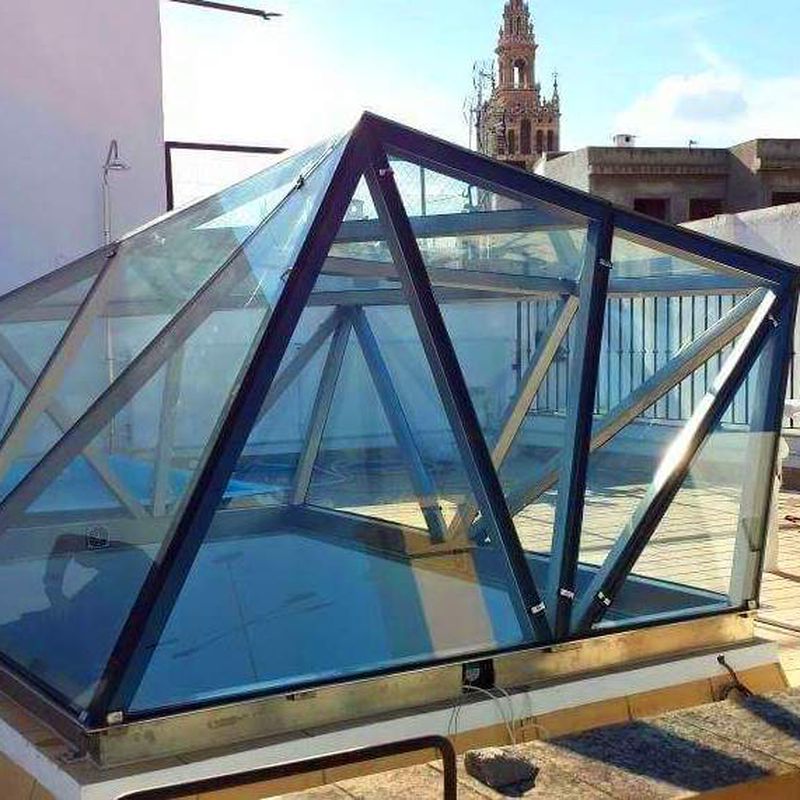 Montera de diseño de acero inoxidable y vidrio montada como punto de luz para patio interior. 