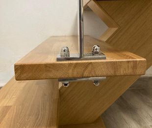 Escalera de peldaños de madera y pasamanos de cristal