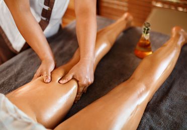Masaje terapéutico de piernas con aceites esenciales